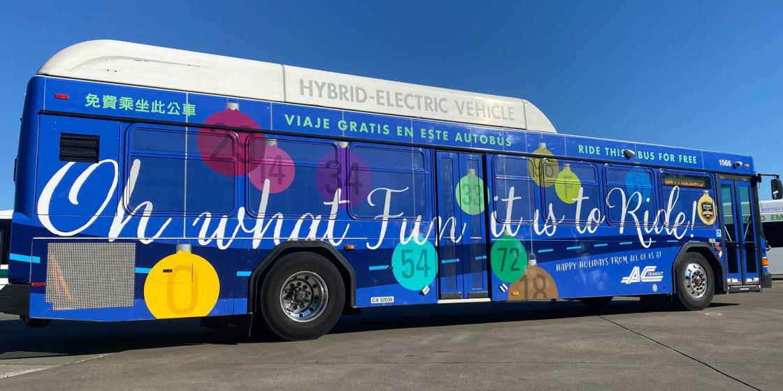 2023 AC Transit Holiday Bus - Bus is blue with cursive writing saying, "Oh what fun it is to Ride!"